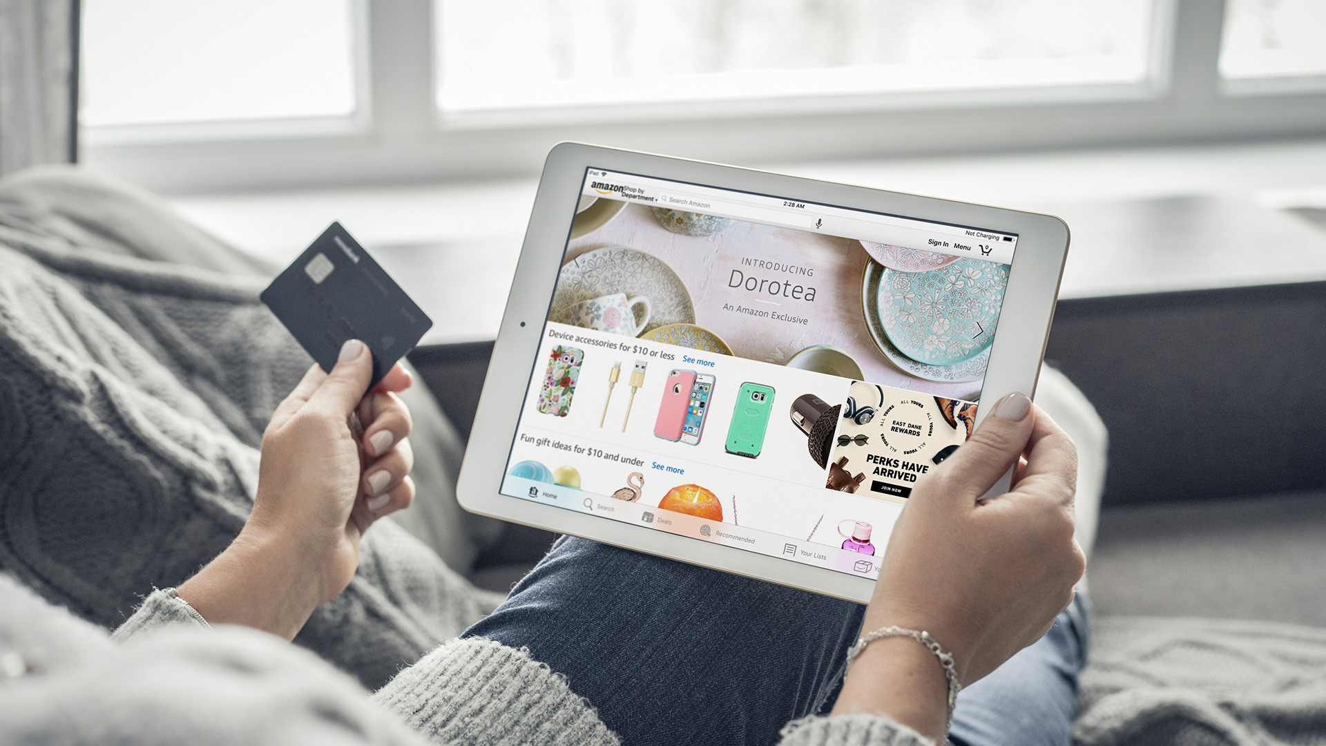 amazon shopping online a woman is holding a card and a tablet