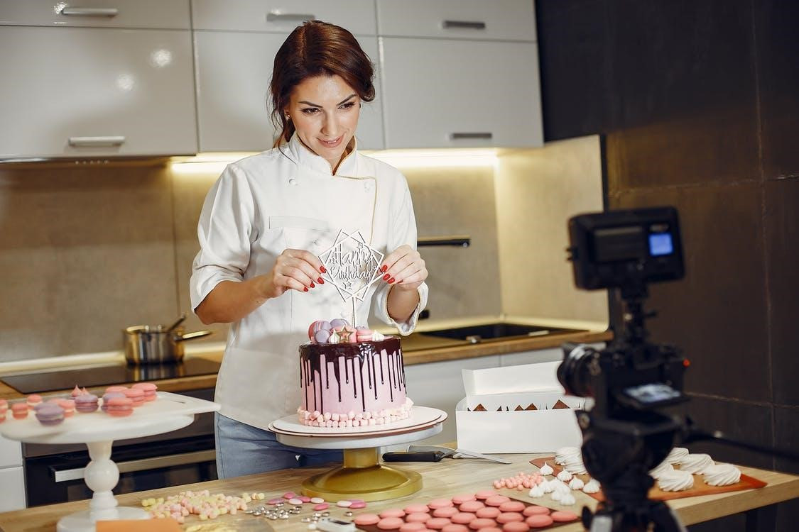 a woman is putting something on a birthday cake